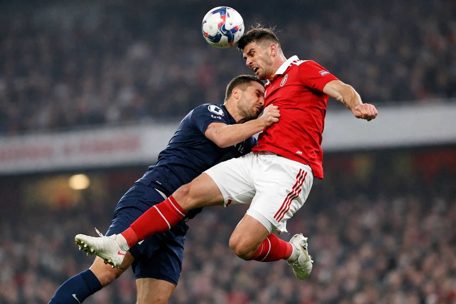 Football striker jumping to head the ball during Premier League match
